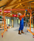 Adjustable Gantry Crane With Trolley And Hoist Heavy Duty 2000 Lbs Capacity Height Range 7.65 To 10.91 Ft 8.5 Ft Wide Shop Garage Crane With Rigging Kit Portable Steel Gantry For Home Workshop And DIY Projects set up in workshop with person adjusting hoist