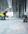 Pro Level 12V Green Beam Cross Line Laser With 100 Foot Reach And Smart Visimax Tech on job site with worker measuring.
