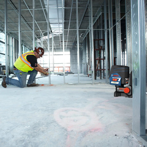Pro Level 12V Green Beam Cross Line Laser With 100 Foot Reach And Smart Visimax Tech on job site with worker measuring.