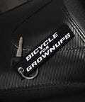 Dope Bicycle For Grownups Keychain For Riders on black leather with key; pocket sized, metal ring visible.