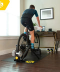 Cyclist using Fluid2 Indoor Bike Trainer For Road And Mountain Bikes With Realistic Road Feel And Progressive Fluid Resistance