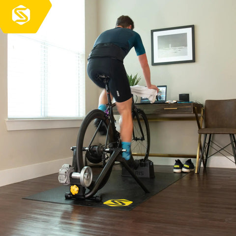 Cyclist using Fluid2 Indoor Bike Trainer For Road And Mountain Bikes With Realistic Road Feel And Progressive Fluid Resistance