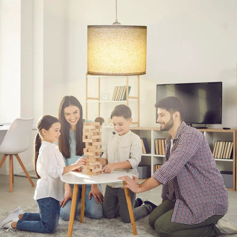 Family enjoying game night under Slick Adjustable Plug In Pendant Light With Authentic Beige Linen Shade in cozy living room.