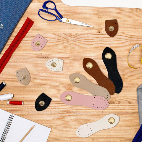 Colorful 15 Piece Leather Snap Buckles Set For Purses And Bags, Sew On Button Closures, displayed on wooden surface with sewing tools.