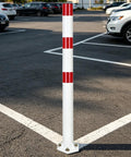 Heavy Duty 32 Inch Stainless Steel Safety Bollards With Bright Reflective Tape Removable Parking Posts For Driveways And Sidewalks Includes Six Concrete Anchors Rock Solid 2 Pack White And Red standing in a parking lot.