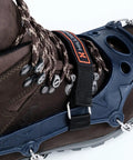Trail Crampon Ultra I Ice Cleat Traction System attached on a brown hiking boot, showing heat treated stainless steel spikes