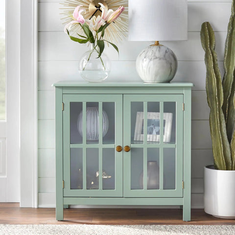 Light green cabinet with glass doors, featuring Antique Brass Cabinet Knobs 6 Pack With Spacers And Backplates.