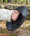 Hand holding Beefy Battle Ready 11 Inch Small Medieval Buckler Shield With Rolled Rim And Riveted Grip 16 Gauge Mild Steel