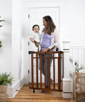 Wood Banister And Stair Safety Gate For Babies And Pets, Adjustable 32 To 48 Inches Wide, 33 Inches Tall, Oak Finish in doorway
