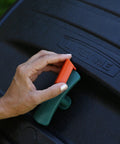 Person using handle on dual compost tumbler with two 50 gallon chambers for no fuss turning black outdoor garden bin