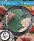 Close-up of 12X Lighted Floor Magnifier with Flexible Gooseneck Clamp Stand showing embroidery detail, 5.2 inch lens in use.
