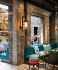 Industrial Plug In Wall Light E26 Base Edison Wire Retro Style Vintage Wall Lights Cage Rustic Sconce installed in modern bar setting.