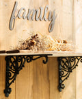 Heavy Duty Wrought Iron Shelf Brackets Two Pack Antique Black Corbels under a wooden shelf with dried flowers.