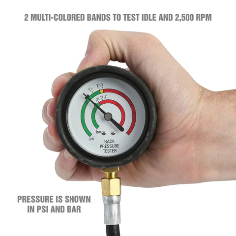 Hand holding exhaust back pressure tester gauge showing psi and bar readings with color bands