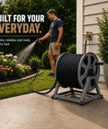 Man watering garden with Beefy Heavy-Duty Garden Hose Reel With 200 Ft Capacity, Dual Floor Or Wall Mount, Graphite Finish