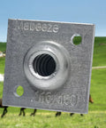 Close-up of aluminum One Way Anchor Vise for 8 to 11 gauge fence wire, showing screw holes and secure grip in outdoor setting.