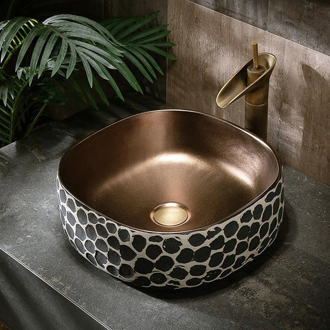 USZWBY Bathroom Vessel Sink 16.9 X 5.9 Inch Bathroom Sink Ceramic Vessel Sink with bronze interior and decorative exterior pattern.