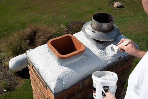Applying Bone Dry Chimney Crown Sealer Brushable Elastomeric Waterproof Membrane on chimney crown with a brush.