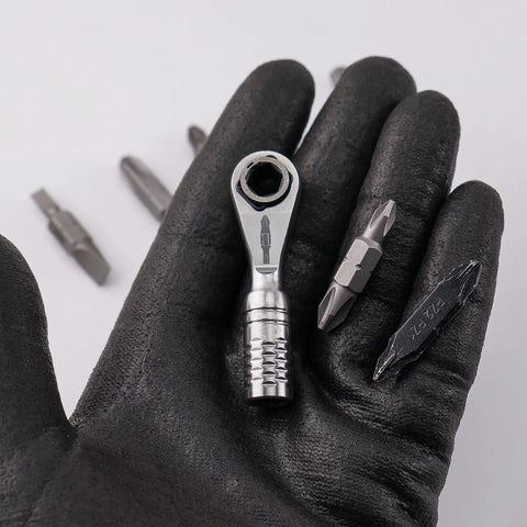 Gloved hand holding Ultra Compact One Quarter Inch Ratchet Wrench For Tight Spaces Stainless Steel EDC Tool with bits