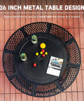 36 Inch Outdoor Fire Pit With Dual Grills And Lid, Black metal table with drinks and snacks on a backyard patio.
