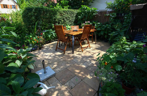 Premium Weatherproof Wood Stain With Semi Gloss Walnut Finish For Indoor And Outdoor Use on a garden patio with wooden table and chairs.