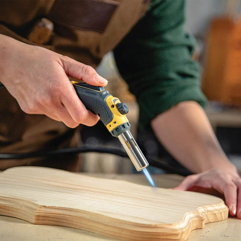 Person using Pro Grade Precision Flame Hand Torch With Adjustable Heat For MAP Pro Propane Fuel on wooden craft project