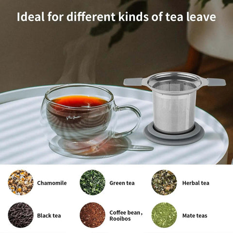 Stainless Steel Loose Leaf Tea Infuser With Extra Fine Mesh Ball Heat Proof Dual Handle Steeper next to a glass cup of tea