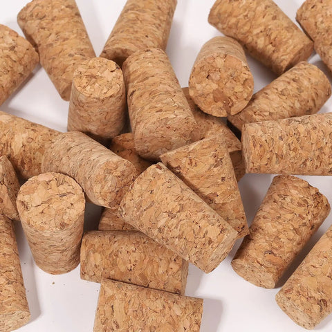 25 Pack Natural Soft Wood Corks, Tapered Bottle Stoppers for Wine Making and DIY Crafts, shown in scattered arrangement