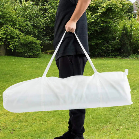 Person carrying a white carry bag for a 10x20 Outdoor Party Tent Canopy With Removable Walls in a grassy backyard.