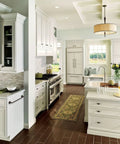 Modern kitchen with white cabinets, stainless steel appliances, and a kitchen island topped with a vase of yellow flowers.