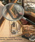 Close-up of Heavy Duty Iron Carabiner Clips Set for Camping and Hiking with magnifying glass, camp tent in background