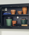 Open cabinet with various gardening pots, folded gloves, and a Tempered Steel Hand Trowel With Wood Handle 13 Inch Garden Tool