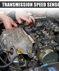 Hands working on a Heavy Duty Transmission Vehicle Speed Sensor for Ford F150 during installation in an engine compartment.