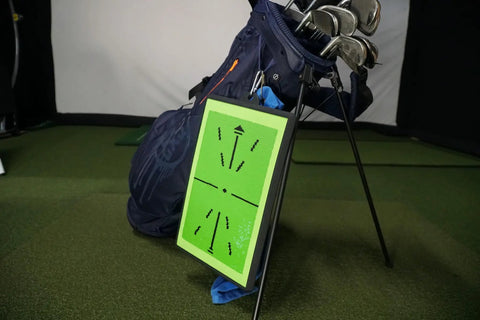 Pro Grade Golf Swing Training Mat That Tracks Ball Impact And Swing Path With Real Time Color Feedback From Green To White leaned on golf bag