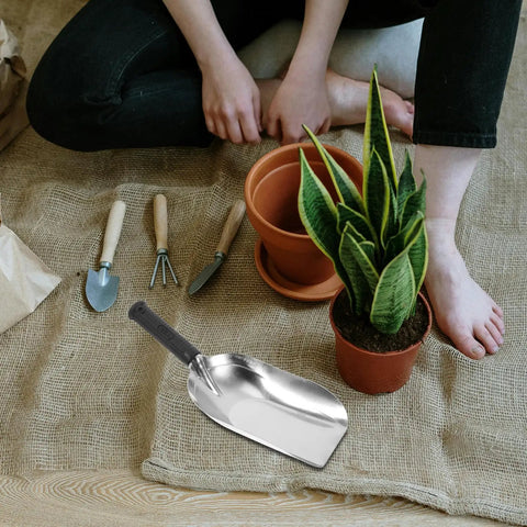 Stainless Steel Garden Hand Trowel Go To Transplanting And Soil Loosening Tool Small Square Shovel next to potted plant