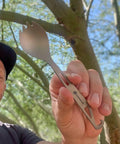 Person holding Ultralight Titanium Spork For Backpacking And Camping Reusable Travel Utensil And EDC Spork With Multi Function Hook