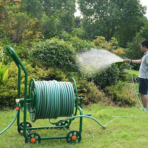 Smooth Operator Garden Hose Reel Cart With Big Rollers Heavy Duty Rolling Stand in use, watering garden with thick hose.