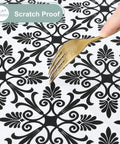 Close-up of a black and white patterned Snug Fit Elastic Fitted Vinyl Table Cover For 6 Foot Tables, being tested for scratch resistance.