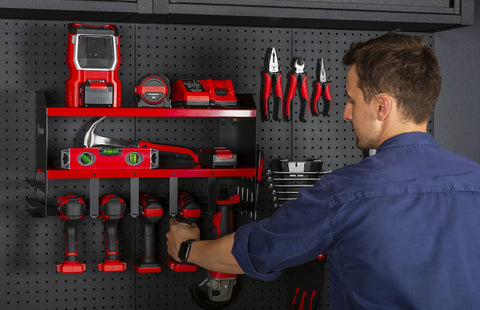 Person organizing tools on Heavy Duty Wall Mounted Power Tool Organizer With Drill Holder, Garage Storage Rack, 2 Shelves, Red.