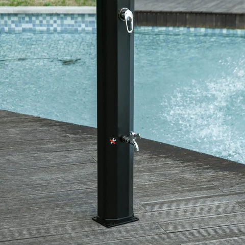 Close-up of black freestanding 7Ft Outdoor Solar Heated Shower with 360 Degree Rotating Head by a pool, showcasing foot shower faucet.