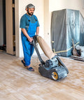 Man using Pro Grade Silicon Carbide Cloth Floor Sanding Belts 24 Grit 8 Inch By 19 Inch Fits Most Small Expandable Drum Sanders Including EZ8 And KT Scorpion 10 Pack Extra Sharp Grain For Fast Clean Sanding And Long Life on hardwood floor