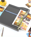ClassicCut Lite 12 Inch Guillotine Paper Cutter with 10 Sheet Capacity trimming photo prints on a sturdy plastic base.