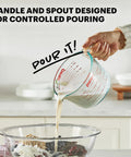 Three Piece Glass Measuring Cups Set With 1 Cup 2 Cup And 4 Cup Sizes for Prep Bake and Cook pouring liquid into bowl in kitchen