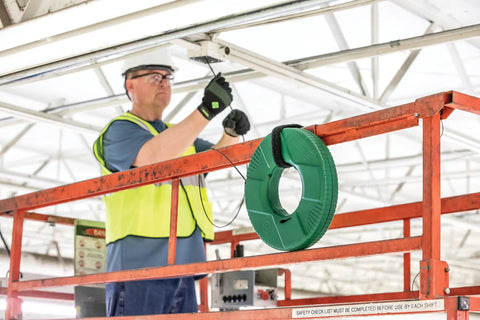 Worker using Reel X Stainless Steel Fishtape 240 Foot One Eighth Inch Wide for smooth cable pulling in industrial setting