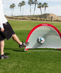 Person kicking soccer ball into Portable Pop Up Soccer Goals For Backyard Set Of Two 4 Foot Nets With Agility Training Cones And Carrying Case