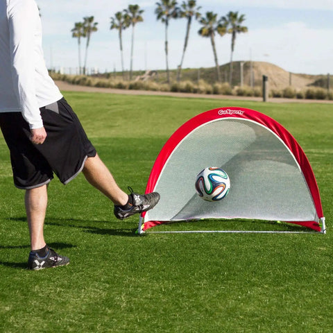 Person kicking soccer ball into Portable Pop Up Soccer Goals For Backyard Set Of Two 4 Foot Nets With Agility Training Cones And Carrying Case