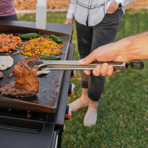 Using tongs from Professional 22 Piece Griddle And BBQ Tool Kit Stainless Steel Dishwasher Safe For Quick Cleanup