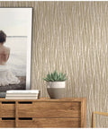 Moonlight Forest Glitter Textured Wallpaper With Flocking, Extra Thick Vinyl Coated in taupe khaki gold, on accent wall with wood dresser.
