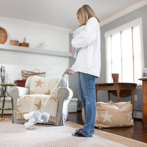 Unger 32-inch grabber reacher tool with built-in magnet picking up a plush toy in a living room