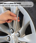 Chrome pencil tire gauge held to a car tire valve; slim metal body with measurement scale.